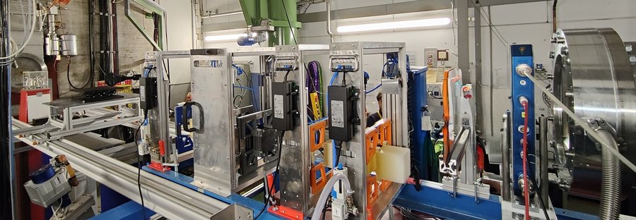 Experimental setup of the GCR simulator at GSI/FAIR Auf einem System aus Alustangen sind kurz hintereinander mehrere rechteckige Halterungen montiert.