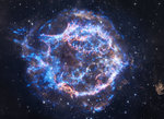 Supernova remnant Cassiopeia A Eine runde Wolke in blauen und gelben Farben erstreckt sich über einen dunklen Sternenhintergrund.